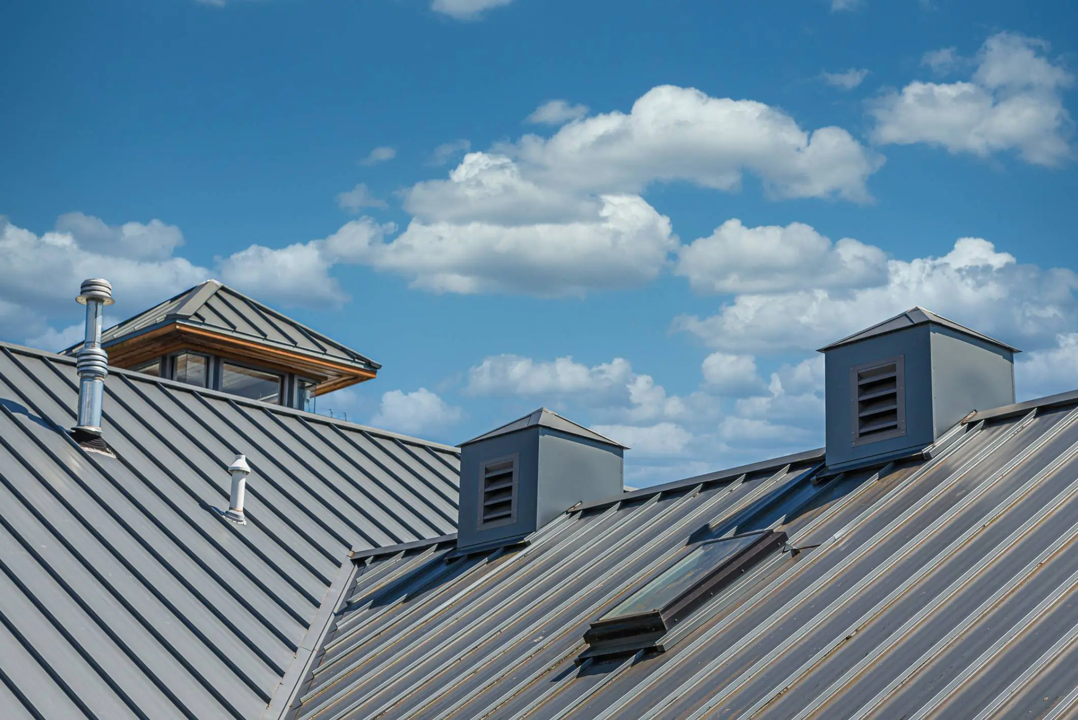 Metal rooftops under a partly cloudy sky.